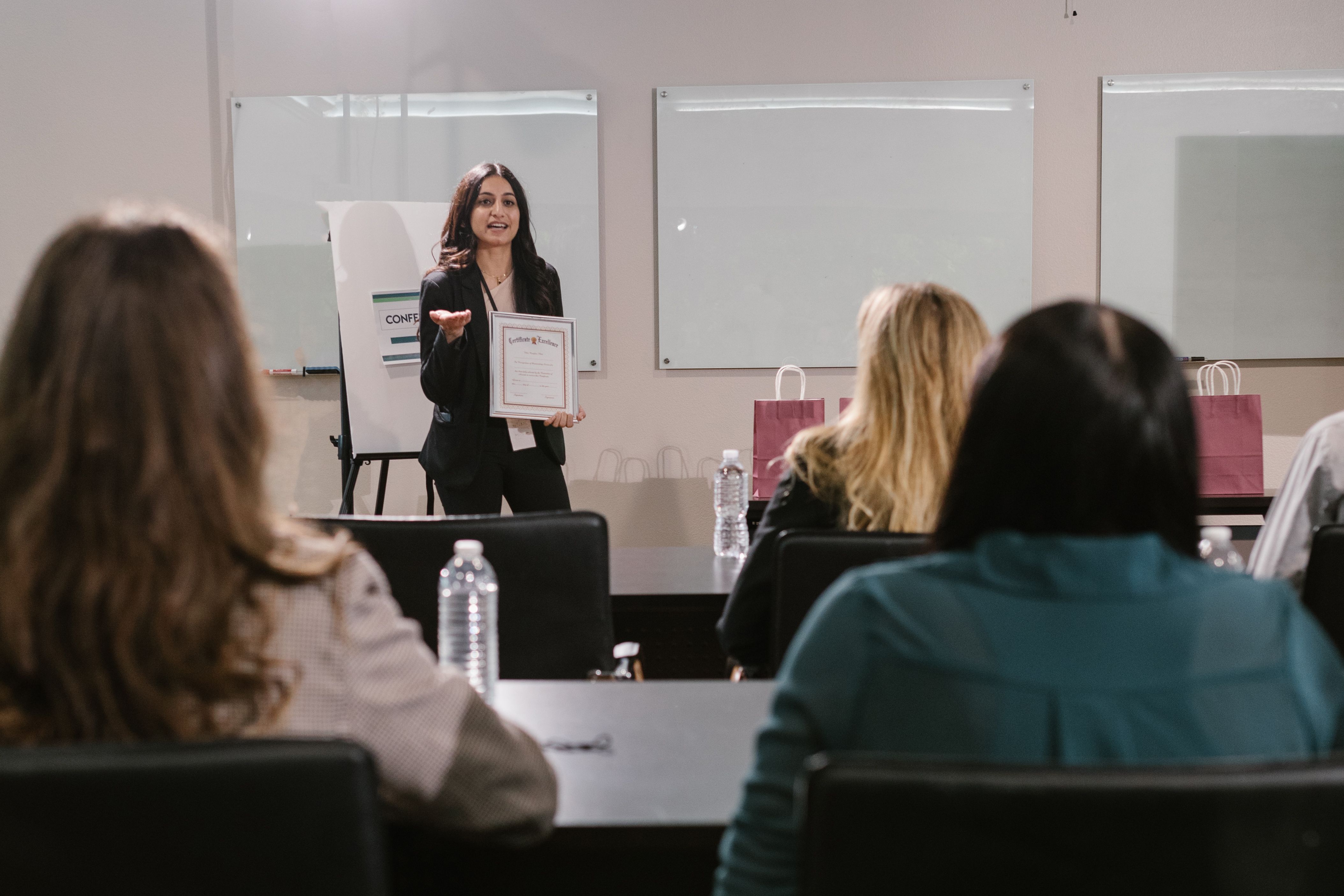 Presenter recognizing an attendee with a certificate during a seminar.