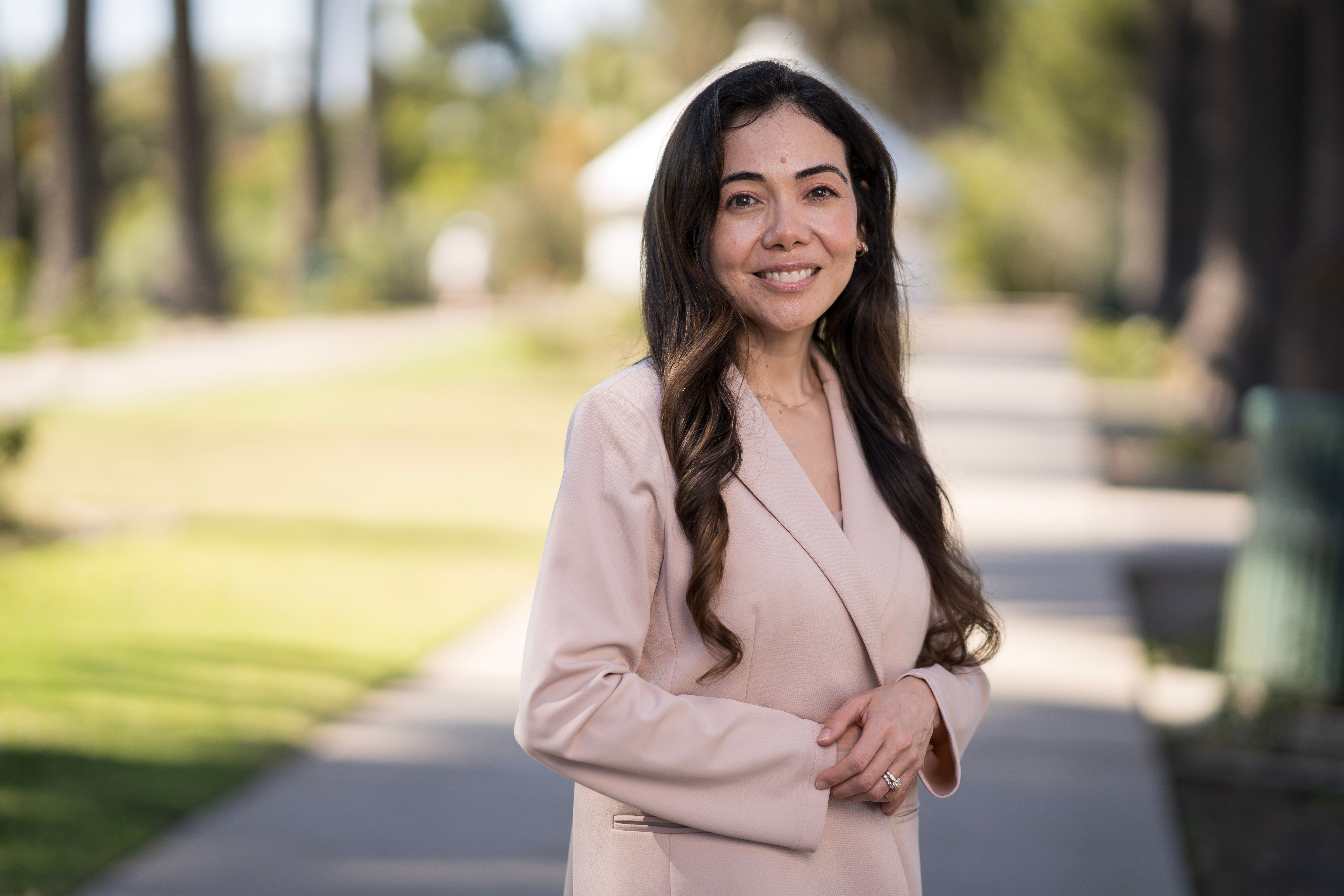 Professional woman posing outdoors for an environmental business portrait.